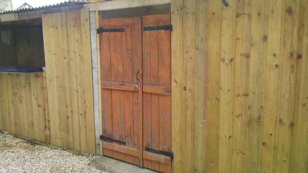 A wooden building with a large, rustic door and a small window. - Pretty Potters' House (Accolay)