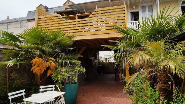 A covered outdoor area with a wooden bench, potted plants, and a brick pathway. - Résidence Les Althéas - Apartment 2 (Villers-sur-Mer)