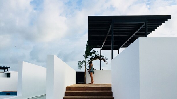 A modern staircase leading to a rooftop area with a pool, surrounded by white walls and a clear sky. - Sleeps 5.  Rooftop infinity pool, 2 bed, 2.5 baths, 2nd floor. Walk to cafes. (Tulum)