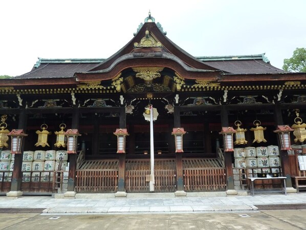 A traditional building with ornate golden decorations, a central entrance, and multiple lanterns.