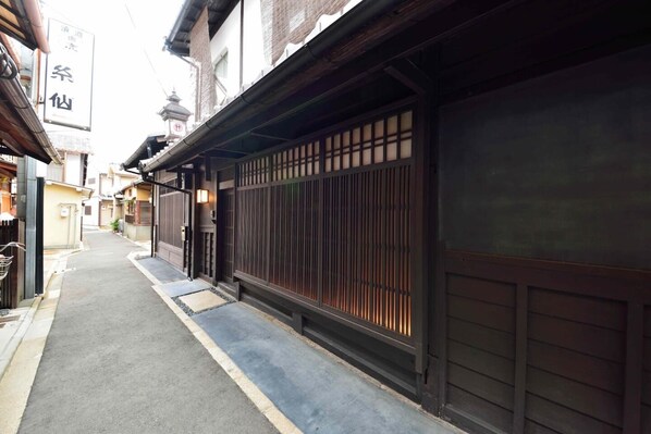 Une ruelle étroite bordée de bâtiments traditionnels japonais, de portails en bois et offrant un chemin dégagé.