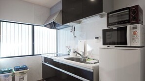 A compact kitchen with a sink, microwave, and dishwasher. - Japanese Modern Townhouse in Gion with Floor Heat (Kyoto)