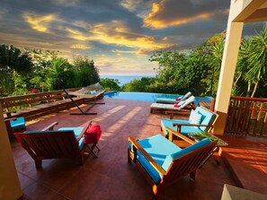 A poolside area with lounge chairs and a hammock, overlooking a pool and a scenic view. - Spacious Beachside Villa on 4 Private Acres (Politilly Bight)