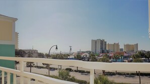 A balcony with a view of a parking lot and buildings in the distance. - In the HEART of Ocean Drive in North Myrtle Beach (North Myrtle Beach)