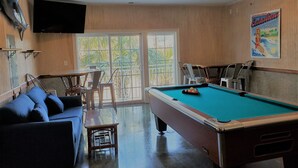 A pool room with a pool table, a sofa, and a ceiling fan. - In the HEART of Ocean Drive in North Myrtle Beach (North Myrtle Beach)