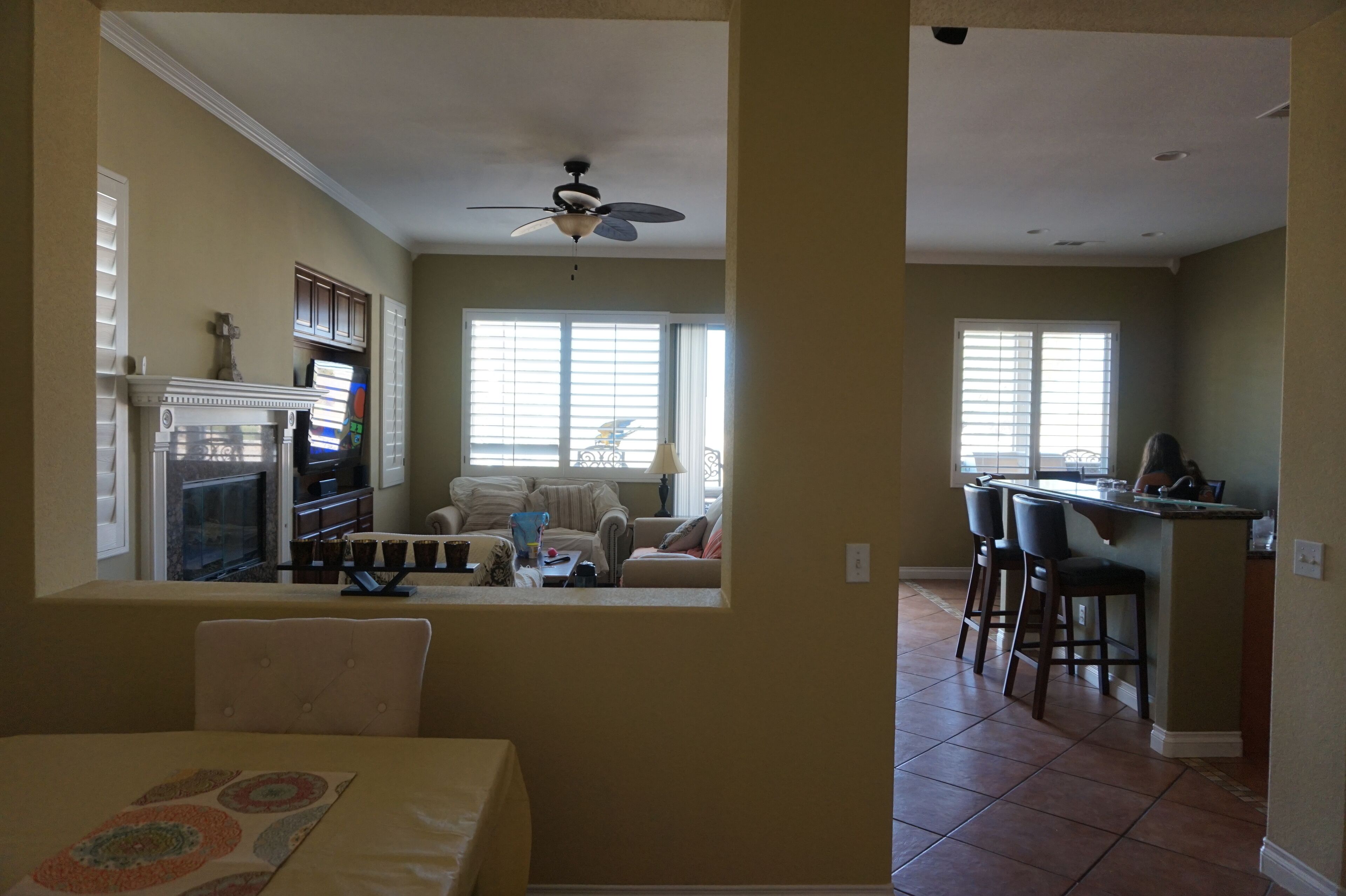 A spacious living room with a fireplace, a dining area with a table, and a kitchen with a bar.