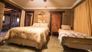 Een slaapkamer met twee bedden, een houten deur en een poster aan de muur.