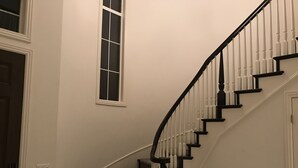 Un escalier en colimaçon avec des rampes noires et un revêtement de sol en moquette.