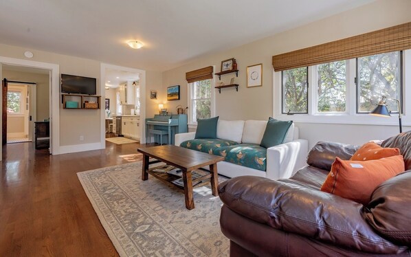 A spacious living room with a sofa, coffee table, and a television.