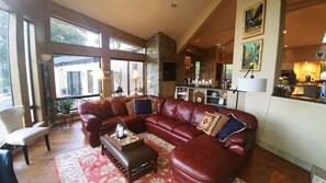 Relax in this inviting living area with a large sofa, wooden coffee table, and stone fireplace.