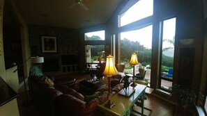 Relax in a comfortable seating area with a sofa and armchairs, coffee table, and TV.