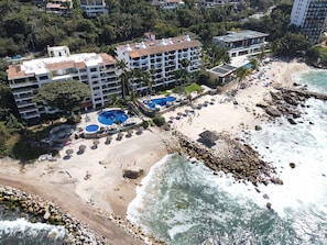 Een resort met meerdere gebouwen, een strand en een zwembad.