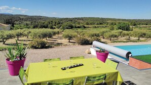 An outdoor dining area with a pool, surrounded by a vineyard landscape. - 3 bedroom cozy home in Quarante (Quarante)