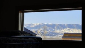Une pièce dotée d’une fenêtre donnant sur des montagnes enneigées.