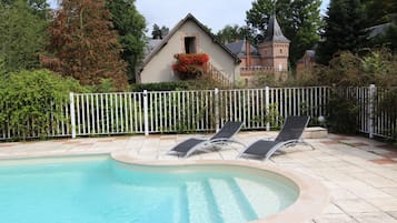 Una piscina al aire libre de temporada, tumbonas