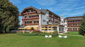A hotel with outdoor seating, a restaurant, and flower boxes on balconies. - Single room category A - Ferienhotel Schönruh e.U.**** (Villach)