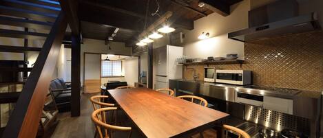 Una cocina moderna con una mesa y sillas de madera, electrodomésticos de acero inoxidable y un salpicadero de azulejos.