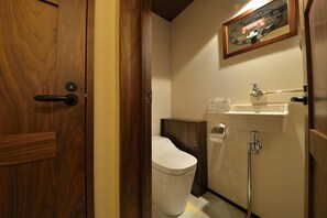 Bathroom features a toilet, sink, and soap dispenser.