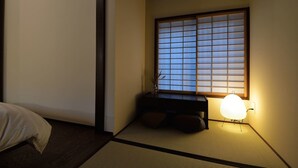 A traditional Japanese room with tatami flooring, a low wooden desk, a shoji screen window, and a bedside lamp. - TAKEYA Gojo East  (竹屋五条東館) (Kyoto)