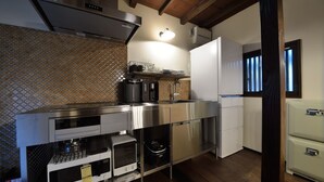 A compact kitchen with stainless steel appliances, a patterned backsplash, and a built-in oven. - TAKEYA Gojo East  (竹屋五条東館) (Kyoto)