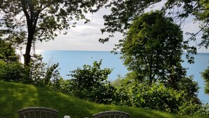 Une vue sur un lac, avec des arbres au premier plan et un ciel dégagé.