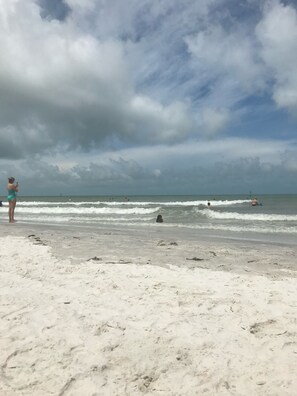 Een strand met een zandstrand en golven.