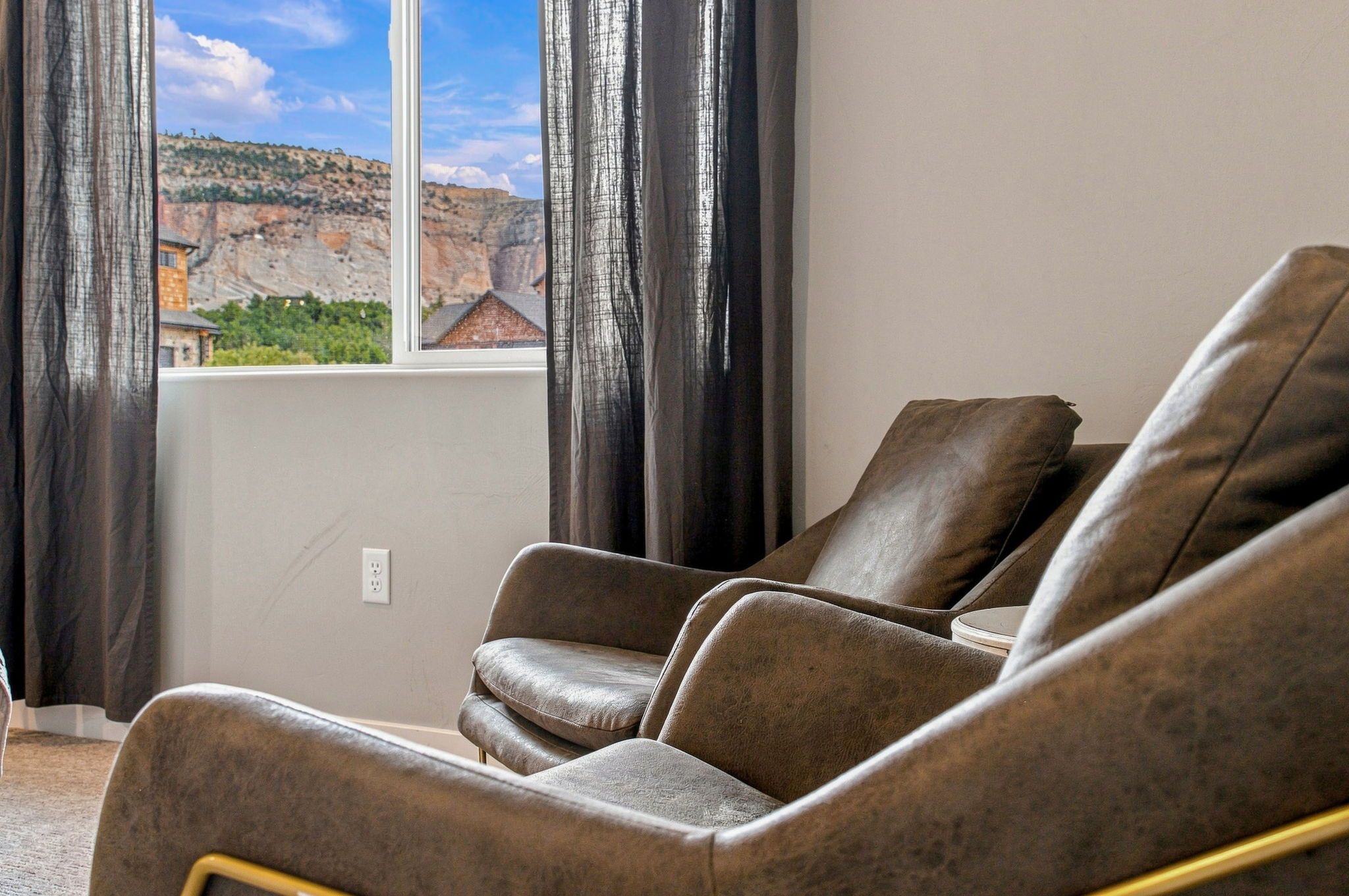 A room with a large window, a sofa, and curtains.