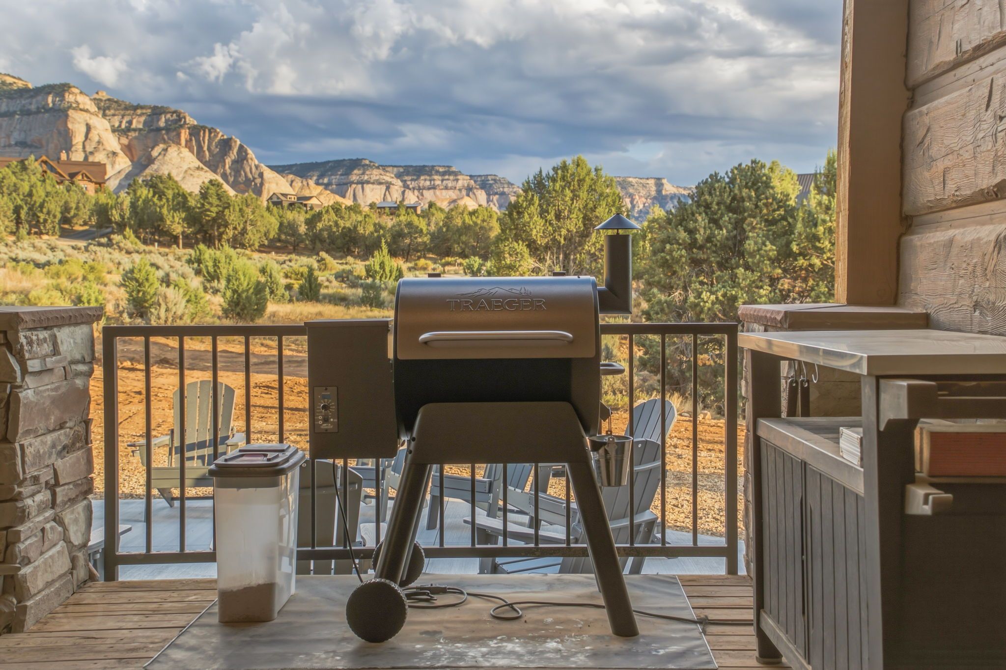 A barbecue grill on an outdoor deck with a view of a mountainous landscape.