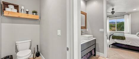 A bathroom with a toilet, sink, and shower area.