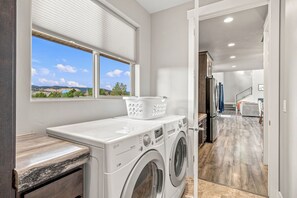 A laundry room with a washing machine, dryer, and a window with a view of the outdoors. - Welcome to Daybreak Mountain Retreat! Gather your family & friends in our spacious mountain home surrounded by incredible Southern Utah views. Sleeps 16 (+6 studio) with room to relax, reconnect & adventure—just 15 minutes from Zion’s East Entrance. (Orderville)