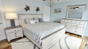 A bedroom with a bed, nightstands, dresser, and a ceiling fan. - Hawk's Nest Boyette Condo 1D: Centrally located with Pool (Ocracoke)