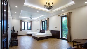 Ein geräumiges Schlafzimmer mit einem großen Bett, einer Sitzecke mit Tisch und Stühlen sowie einem Balkon mit Vorhängen.