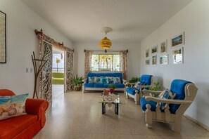 A living room with a sofa, armchairs, a coffee table, and a decorative gate. - Casa Babi (Cienfuegos)