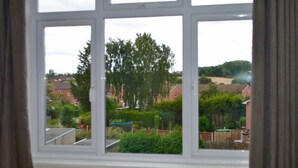 Une fenêtre donnant sur un quartier résidentiel, avec vue sur des maisons et des espaces verts.