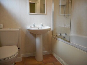 Un baño con inodoro, lavamanos y ducha.