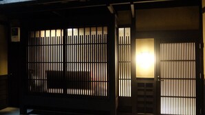 Un edificio japonés tradicional con una puerta de madera y un farolillo iluminado.