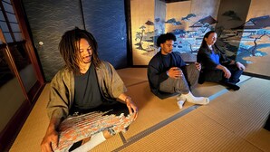 Una habitación con esteras de tatami y decoración tradicional japonesa, incluyendo paneles shoji y caligrafía.