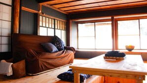 Una habitación tradicional japonesa con suelo de tatami, una mesa de madera baja y un futón.
