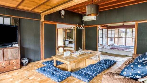 Una habitación tradicional japonesa con suelo de tatami, una mesa de madera baja y una cama futón.