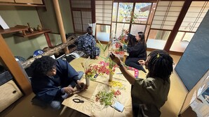 Una habitación japonesa tradicional con suelo de tatami, paneles shoji y una mesa baja con un juego de té.