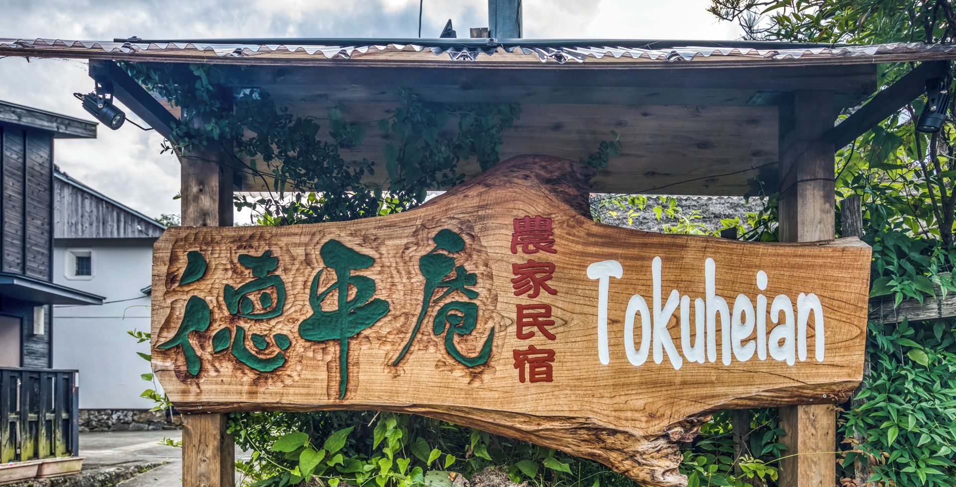 A wooden sign with Chinese characters and the name "Tokueihan" in English, indicating a location or establishment.