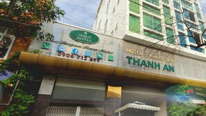 A hotel with a sign reading "THANH AN HOTEL" and a contact number. There is a red car parked in front. - Thanh An Hotel (Ho Chi Minh City)