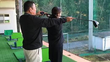 A person aiming a golf club at a target.