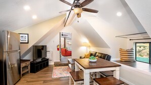 A modern kitchen with a built-in refrigerator, wooden flooring, and a dining area with a table and benches. - Apartment #1 GREAT LOCATION Zion National Park entrance as close as you can get! (Springdale)