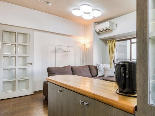A compact kitchen with a wooden countertop, a built-in stove, and a coffee maker. - Convenient to Dotonbori,OsakaCastle (Ōsaka-shi)