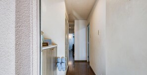 A narrow hallway with a door on the left, a white wall, and a wooden floor. - Convenient to Dotonbori,OsakaCastle (Ōsaka-shi)