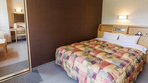 Ein Hotelzimmer mit Bett, Schreibtisch und Stuhl.