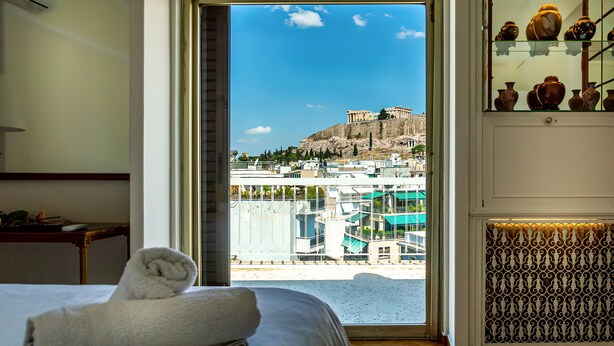 Una habitación de hotel con un ventanal que ofrece vistas a un edificio histórico y al paisaje urbano.