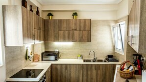 Una cocina moderna con armarios de madera, un microondas integrado y un lavamanos.