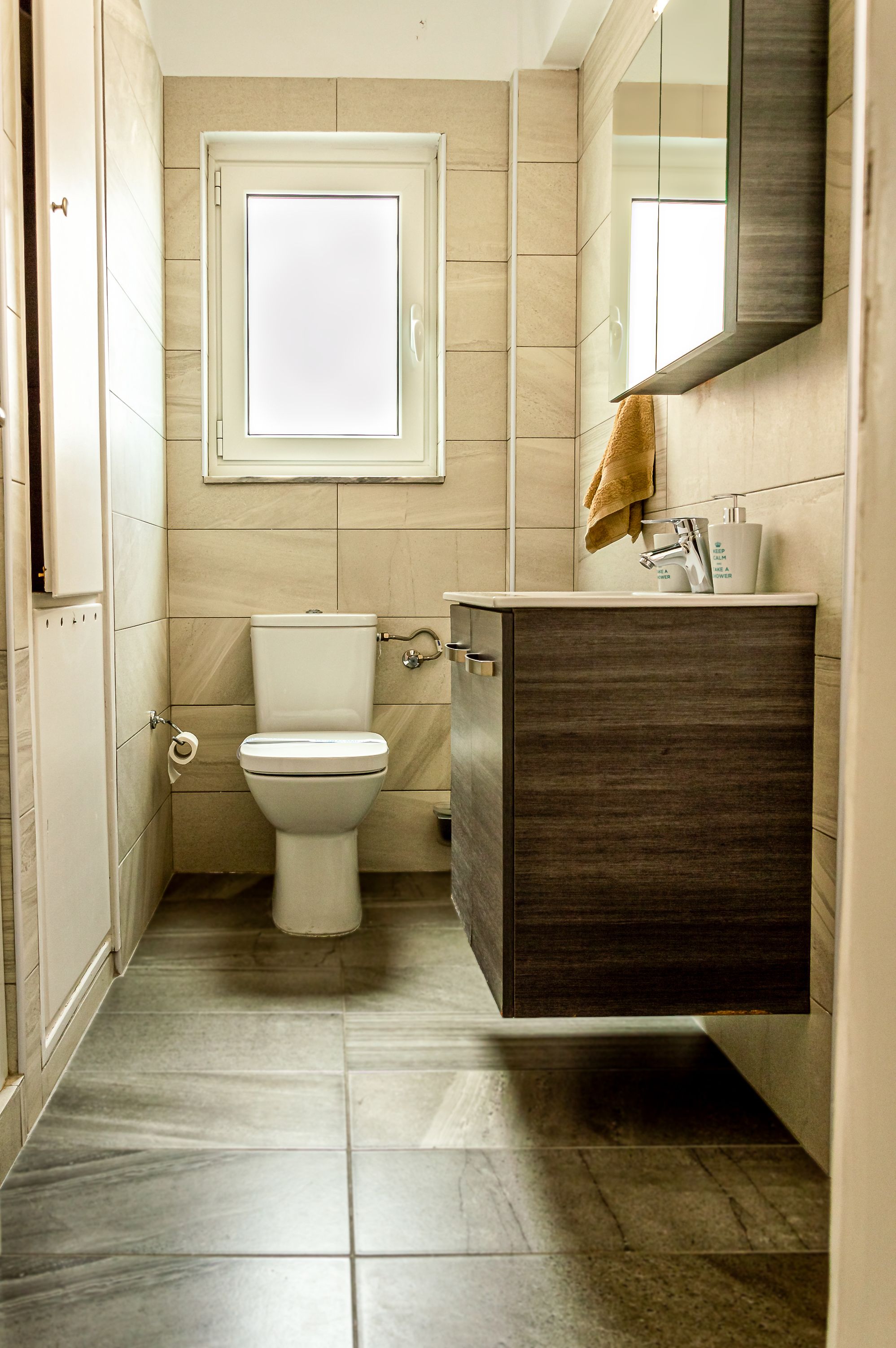 Une salle de bain avec des toilettes, un lavabo et un miroir.
